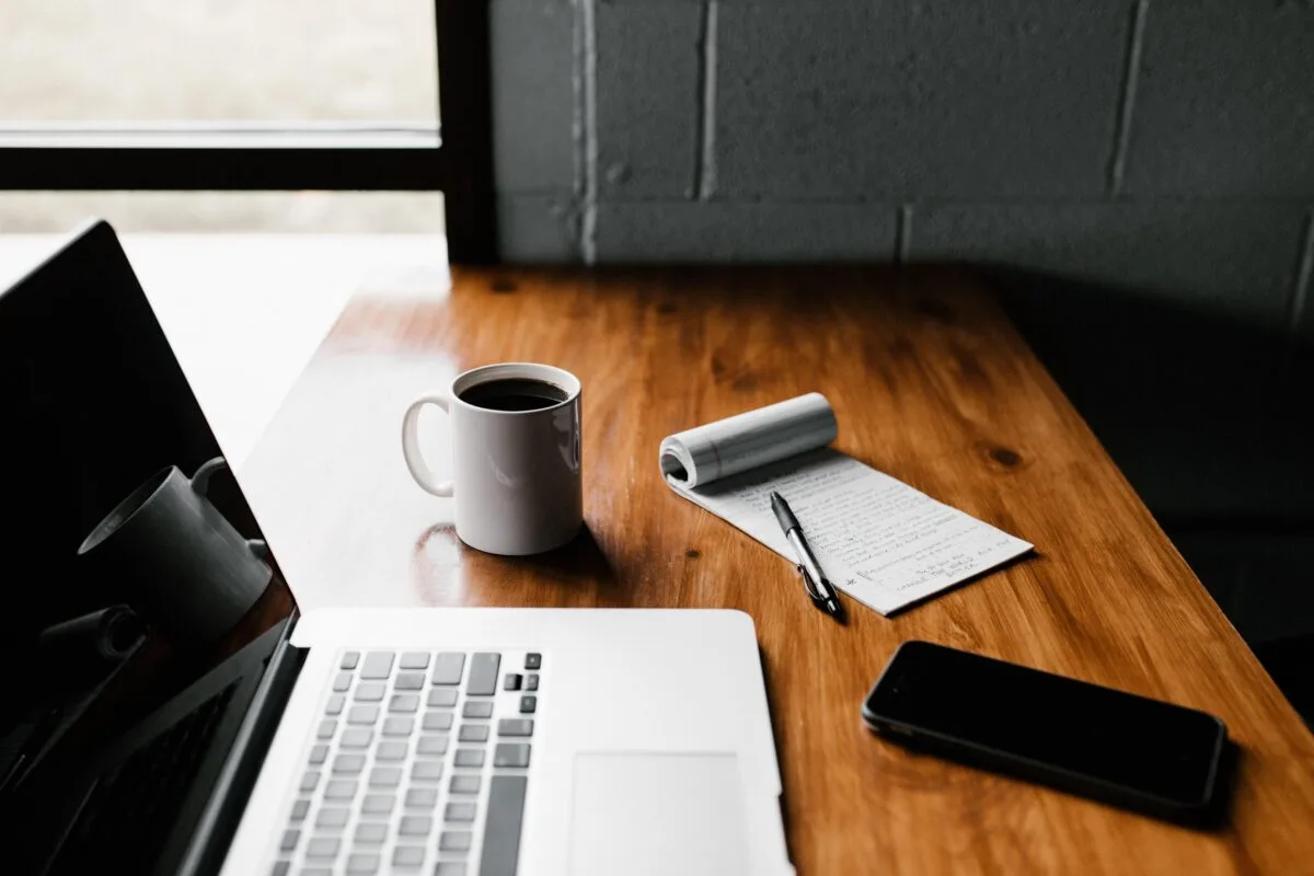 Ordinateur portable et smartphone sur une table avec une tasse blanche