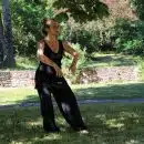 woman in black tank top and black pants standing on green grass field during daytime