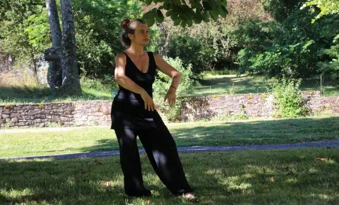 woman in black tank top and black pants standing on green grass field during daytime