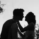 silhouette grayscale photo of man and woman attempting to kiss