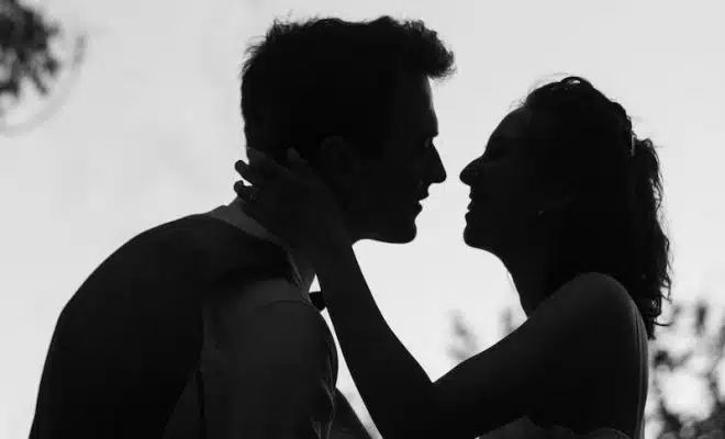 silhouette grayscale photo of man and woman attempting to kiss